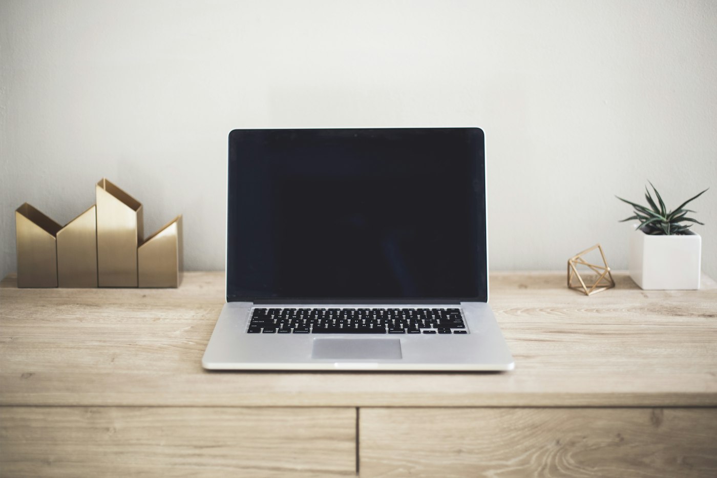 A laptop on a neatly arranged wooden desk