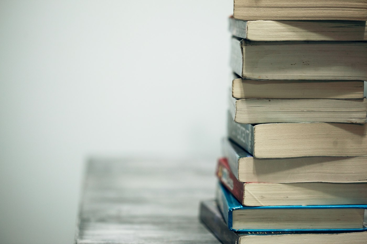 A modest stack of books beside an empty wall