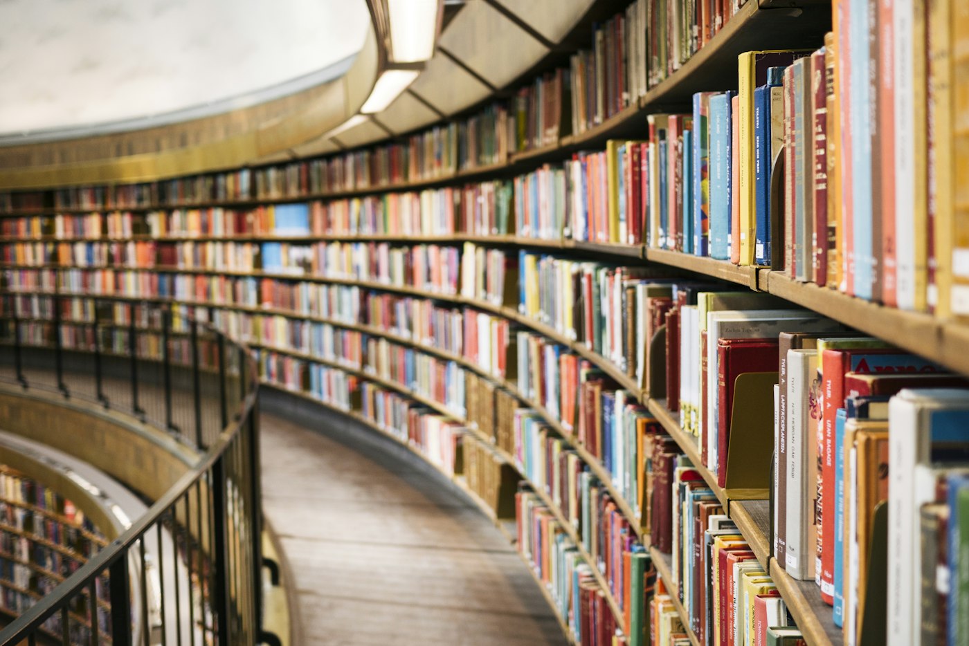A curving aisle lined with library bookshelves