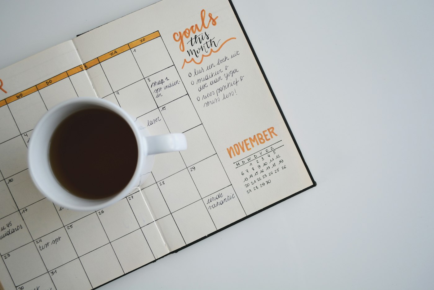 An open paper calendar with a cup of coffee
