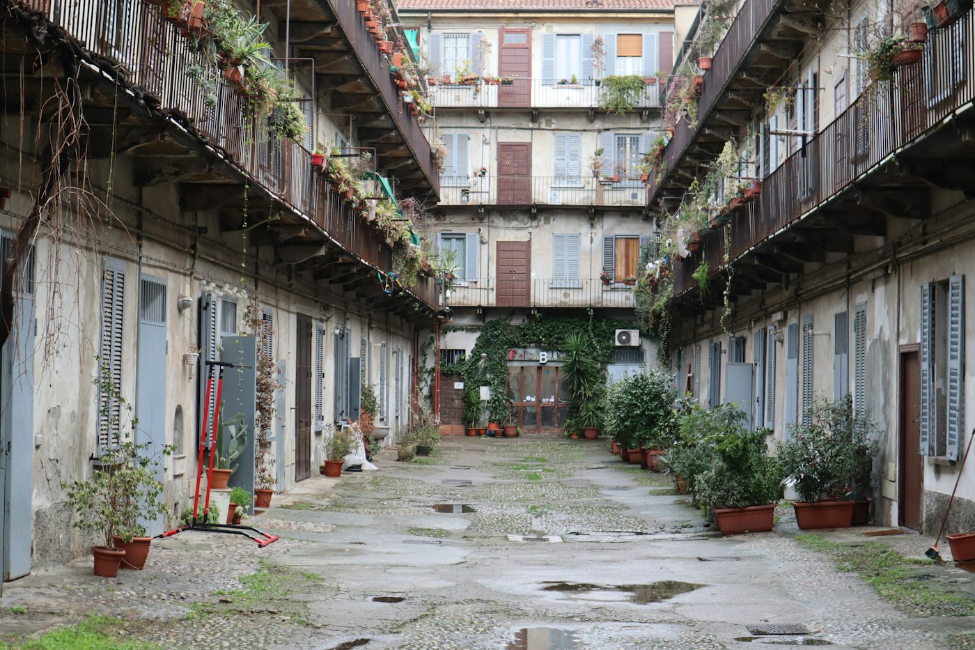 A residential courtyard with balconies and potted plants
