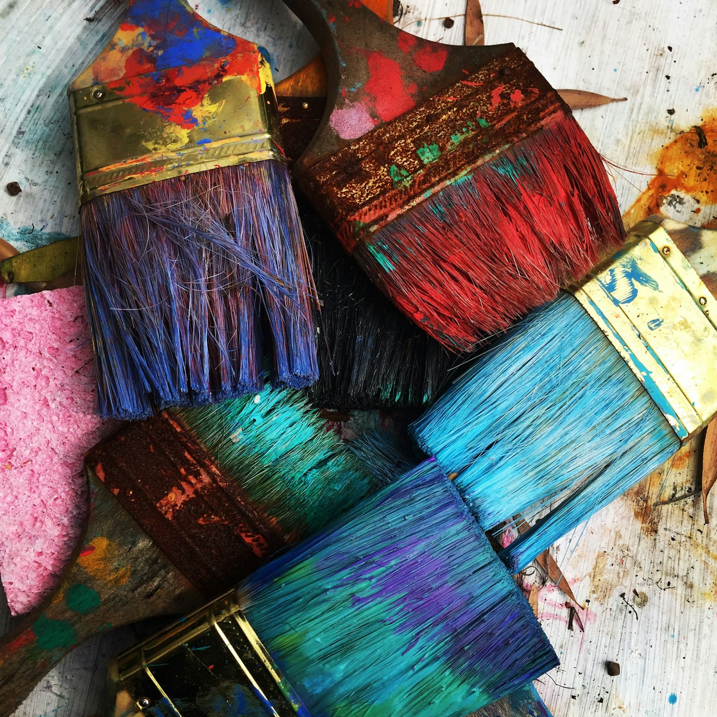 Used paintbrushes with many layers of colored paint