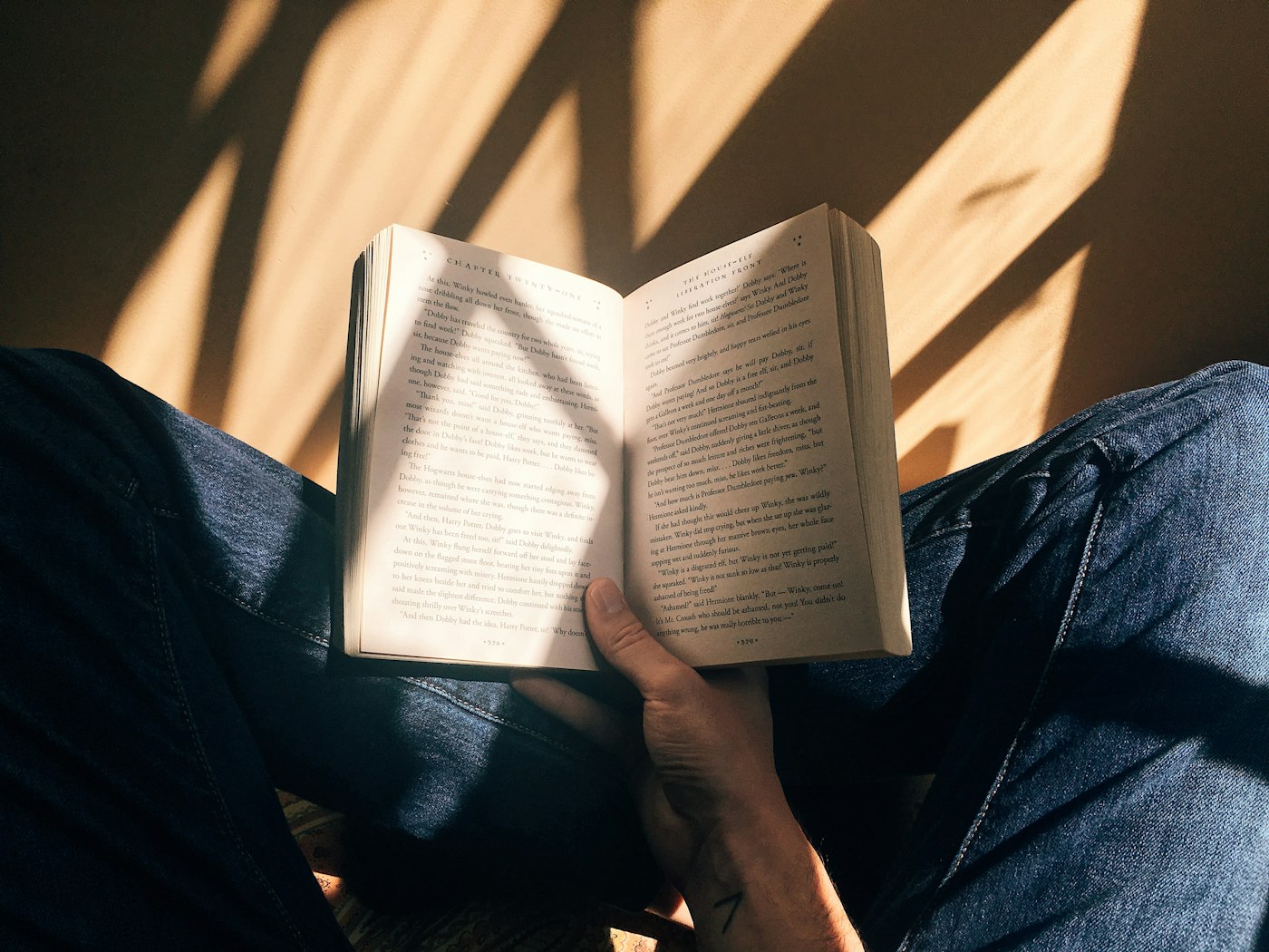 An open book resting on the lap of a reader